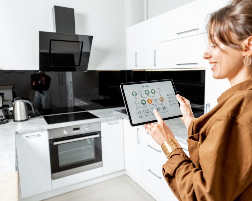 young woman in a bright, modern kitchen, holding a tablet
