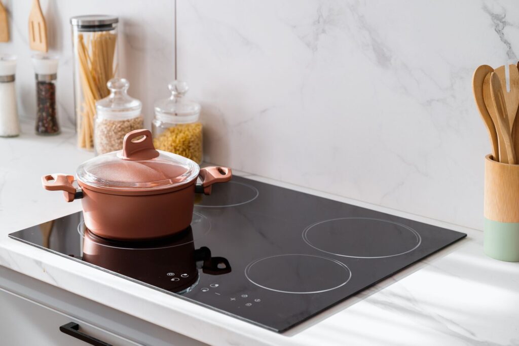 induction cooktop with a pot on it. Induction cooktops use electromagnetic energy to heat cookware directly, rather than using a traditional gas or electric element