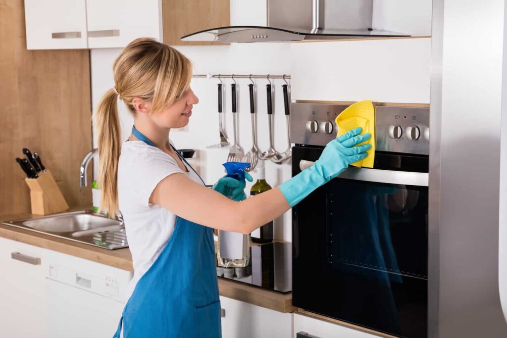 Girl cleaning her oven