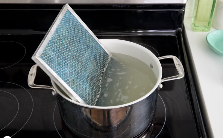 a method for cleaning a range hood filter by soaking it in a pot of hot water on a stove