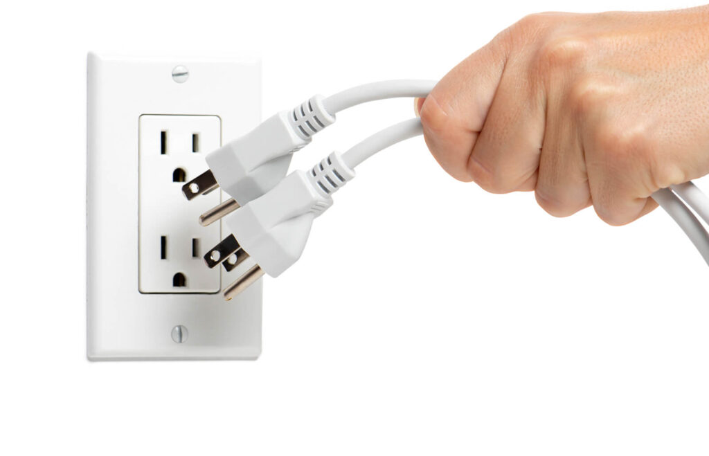 hand plugging two electrical cords