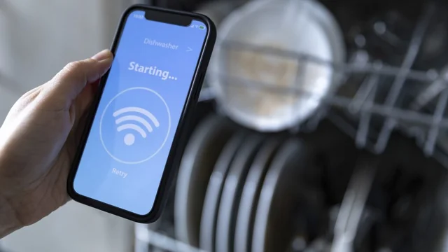 a smartphone using a smart appliance app to control a dishwasher