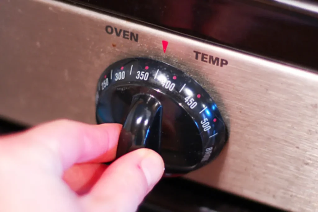 oven temperature control knob being used