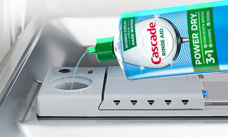 Cascade Rinse Aid, a dishwasher product being poured into a dishwasher's rinse aid dispenser