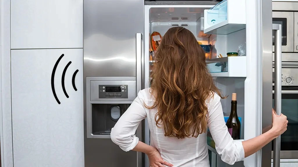 a woman opening a modern refrigerator in a kitchen