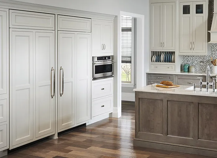 a kitchen with Monogram fully integrated column refrigerators and freezers