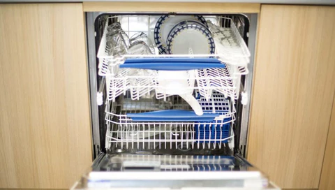 an open, built-in dishwasher filled with dishes, plates, and cutlery