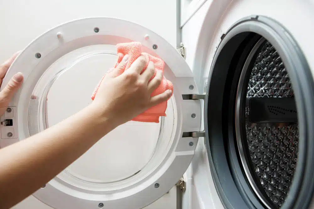 a person cleaning or loading a front-load washing machine