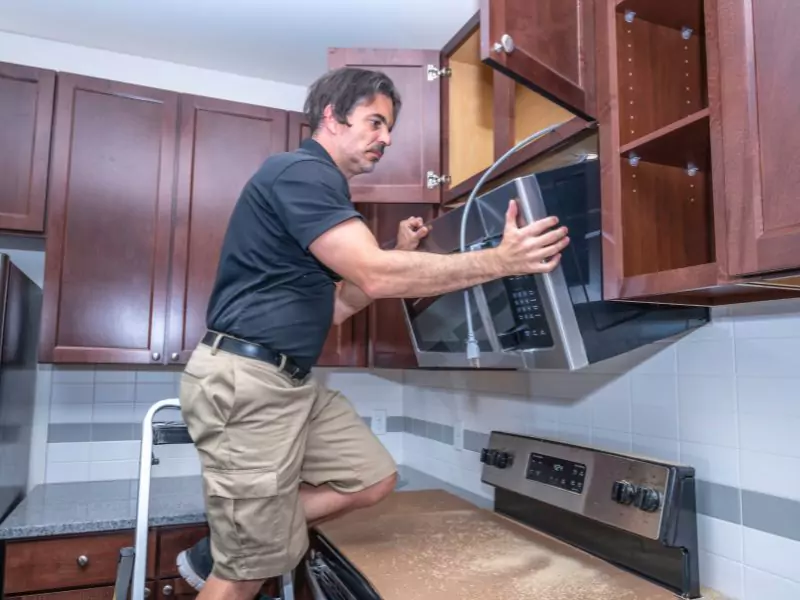 Installing an over-the-range microwave oven. 