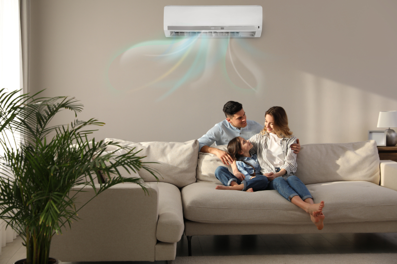 a family relaxing in a room cooled by a ductless mini-split air conditioning system