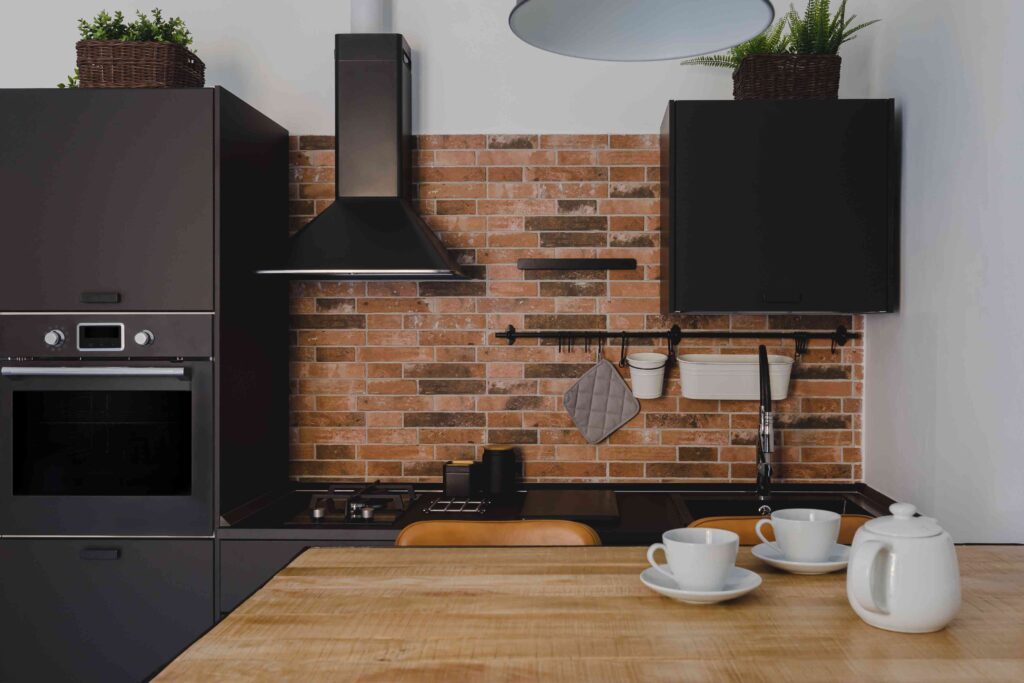 a modern kitchen with black appliances and a brick backsplash
