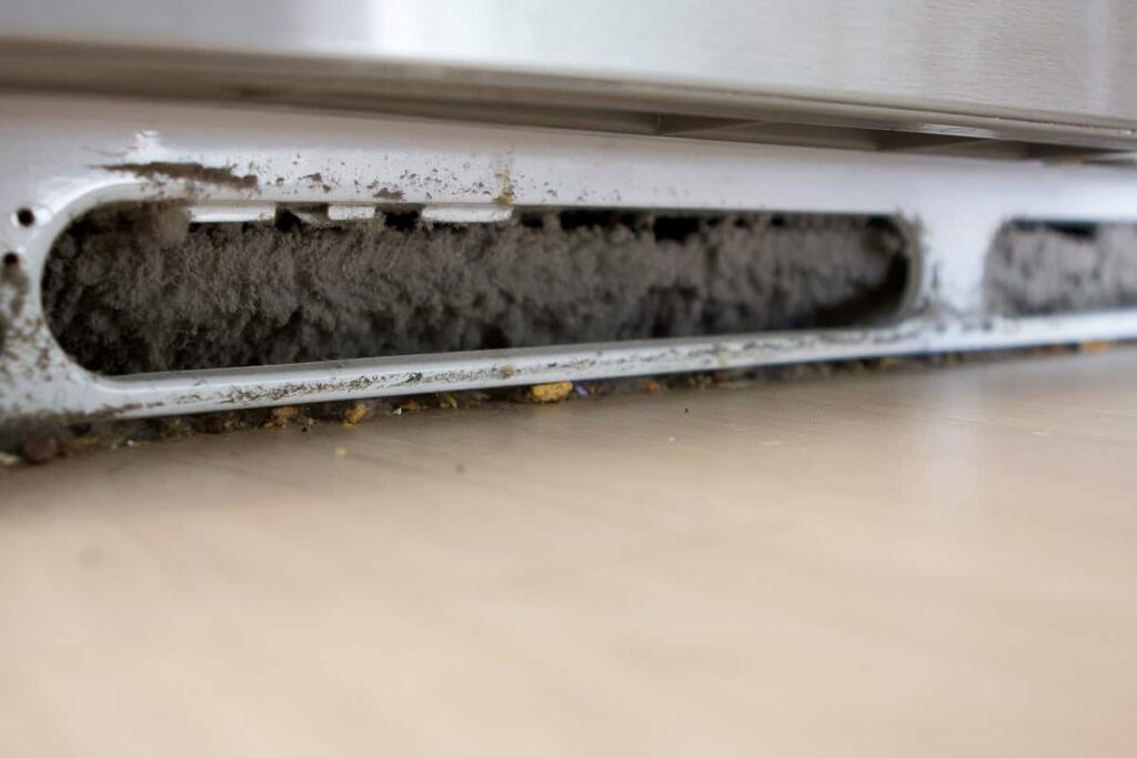 a buildup of dust and debris on refrigerator condenser coils