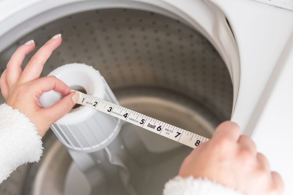 woman measuring washer drum size