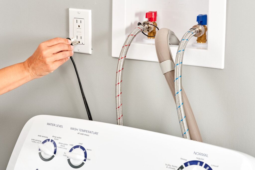 a person connecting or disconnecting a washing machine's power cord and the water supply lines