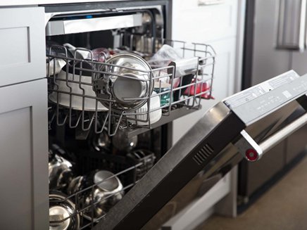 a stainless steel built-in dishwasher with the door open and racks filled with dishes
