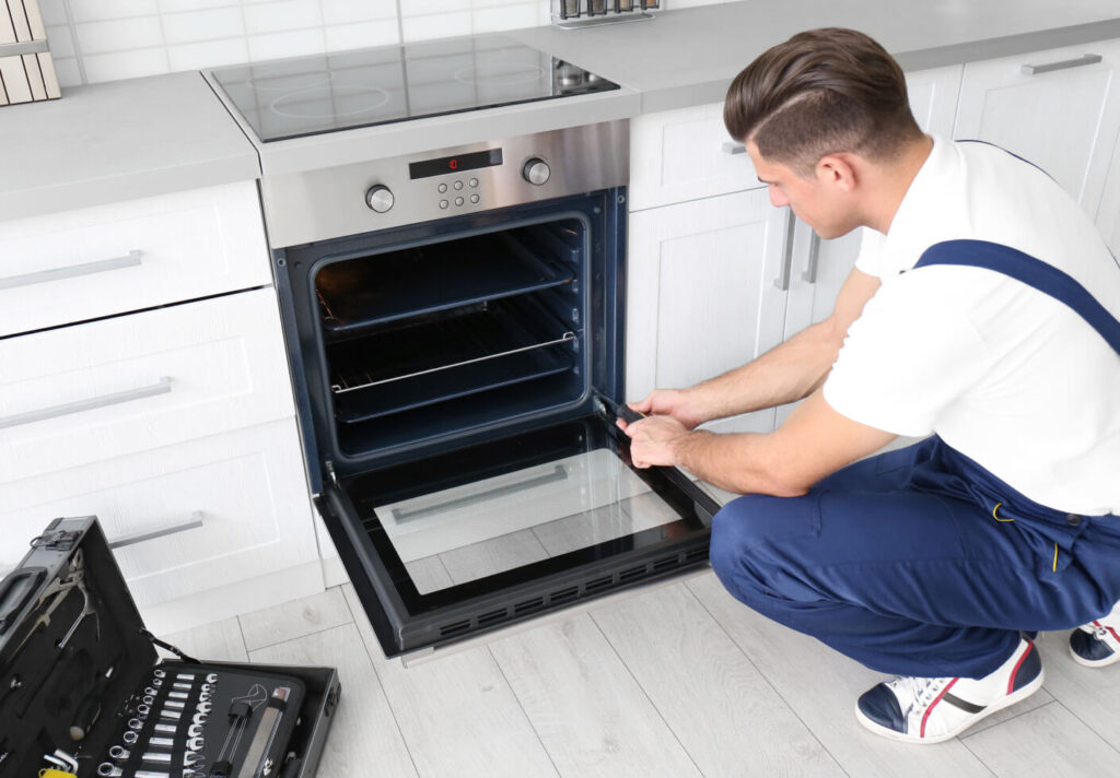 a technician performing maintenance or repair work on a built-in oven