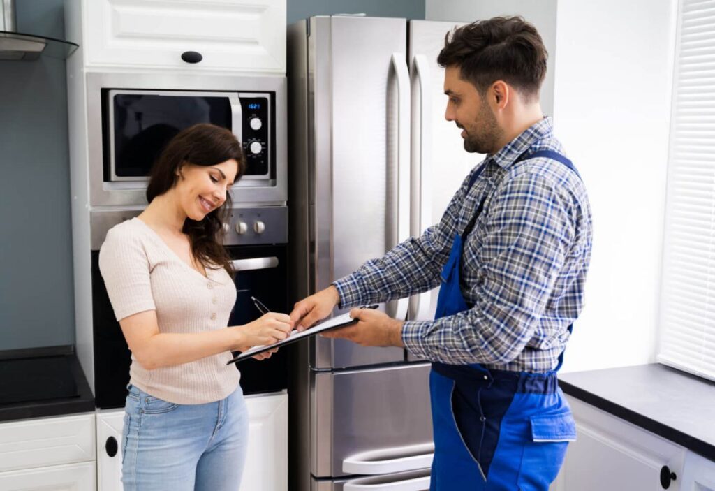 repairman and homeowner at the kitchen for maintenance of appliances